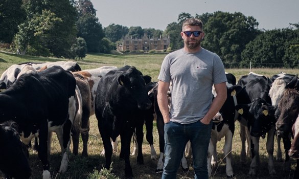 Farmer, Ollie Blackburn, stood among his dairy herd in a field.